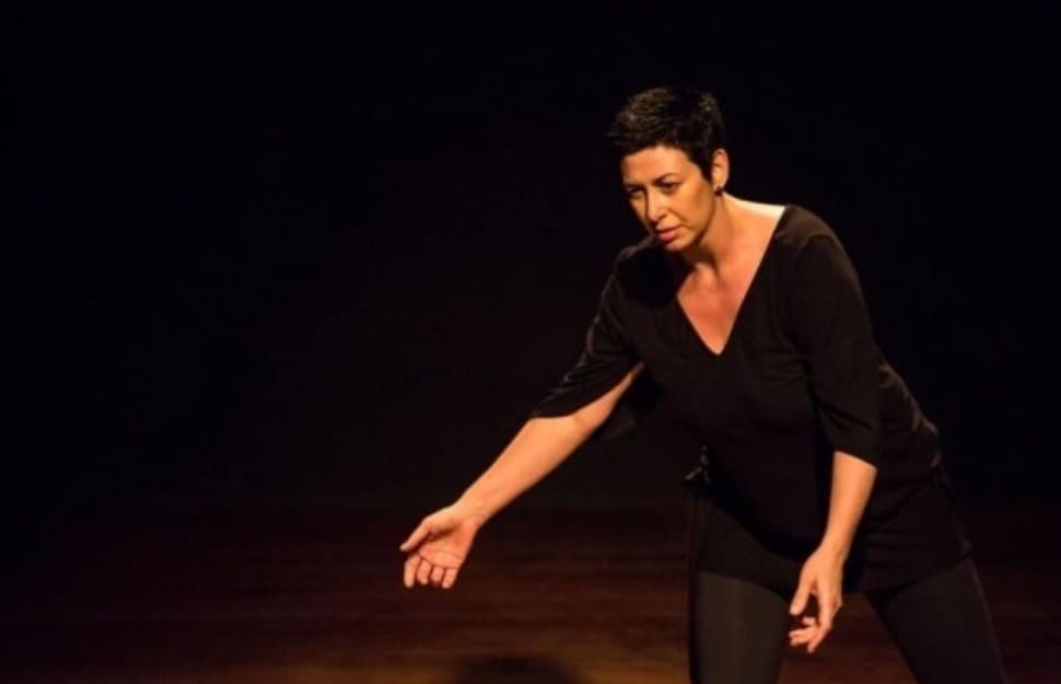 Nevena Mitić on stage, arm outstretched, under warm stage lighting